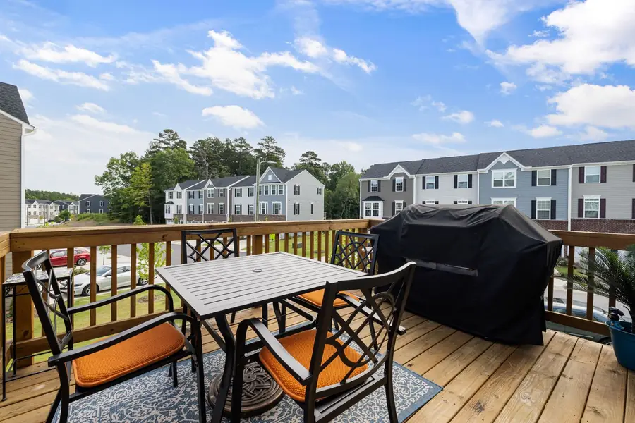 Wood deck with a table and chairs overlooking a neighborhood
